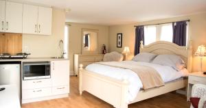 um quarto com uma grande cama branca e uma cozinha em Maison Gauthier em Tadoussac