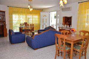 een woonkamer met blauwe stoelen en een tafel bij Villa Romantika in Chrysi Ammoudia