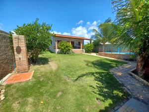 une arrière-cour d'une maison avec une pelouse dans l'établissement Morro Branco, Beberibe-CE, à Morro Branco