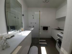 ein Badezimmer mit 2 Waschbecken und einer Waschmaschine in der Unterkunft Pelican Point Waterfront Resort formerly Carnarvon Beach Retreat in Carnarvon