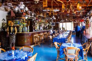 Hotel Oriente في ليباري: رجل واقف امام بار به طاولات