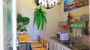 a kitchen with a sink and a counter with a microwave at Pranot Apartment & Spa in Nonthaburi