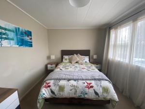 a bedroom with a bed and a window at Poet's Corner in Rotorua