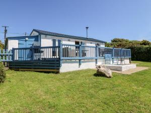 une maison avec une balustrade bleue et un banc dans une cour dans l'établissement Harbour Lights, à Holyhead