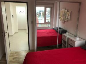sypialnia z czerwonym łóżkiem i lustrem w obiekcie Lo de Moli 1C w mieście Ushuaia