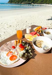 una mesa con un plato de comida en la playa en La Lune Beach Resort, en Ko Samed
