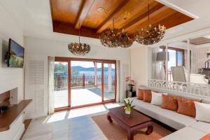 a living room with a couch and a table at Thavorn Beach Village Resort & Spa Phuket in Kamala Beach