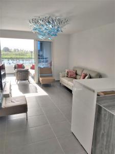 a living room with a couch and a chandelier at Appartement neuf vue Marina étang Z'abricot FDF in Fort-de-France