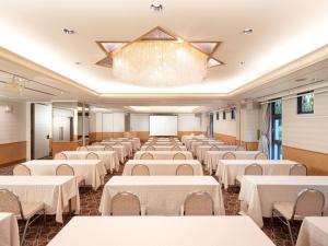 um salão de banquetes com mesas e cadeiras brancas em HOTEL MYSTAYS Hiroshima Peace Park em Hiroshima