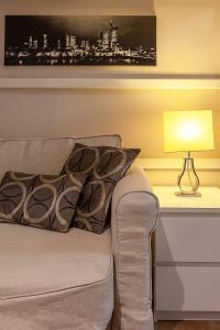 un soggiorno con un divano e una lampada di Apartamento céntrico a 10 minutos de la Alhambra a Granada