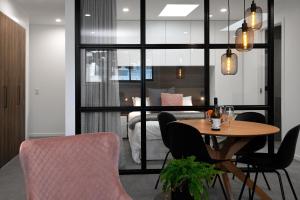 Apartments on Moray في دنيدن: غرفة مع طاولة وكراسي وغرفة نوم
