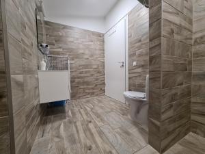 a bathroom with a toilet and a sink at Surman Apartmanok in Siófok +76 photos
