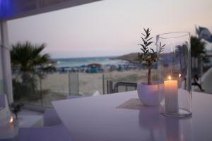 a candle and a plant in a vase on a table at Tasia Maris Beach Hotel - Adults Only in Ayia Napa