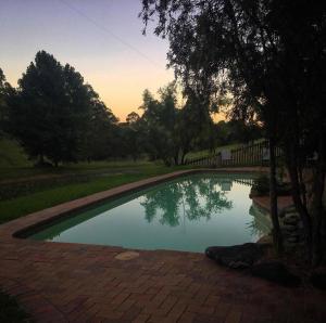 a swimming pool in a yard with trees and a fence at Hidden Haven Barrington Tops in Cobark
