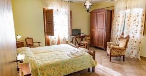 a bedroom with a bed and a chair and a desk at Tenuta Montelaura in Forino