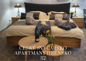 a bedroom with a large bed with a bottle of wine at Hřensko32 in Hřensko