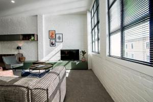 uma sala de estar com um sofá e uma televisão em Apartments on Moray em Dunedin