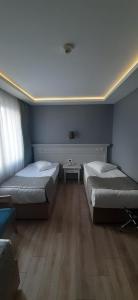 Habitación con 2 camas y mesa. en Semsan Hotel, en Estambul