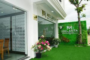 una tienda con flores en la ventana de un edificio en Melanta Hotel en Sầm Sơn