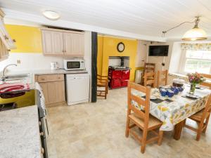 a kitchen and dining room with a table and chairs at Primrose Hill Farmhouse in Hutton le Hole