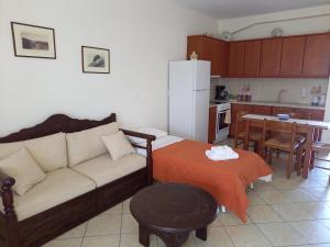 a living room with a couch and a kitchen at To Pithari in Skiros