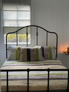 a bed with a black frame and pillows in a bedroom at MOSS and pines by the sea with private parking in Ventspils