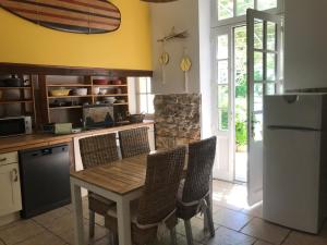 La cuisine est équipée d'une table, de chaises et d'un réfrigérateur. dans l'établissement La Casa Deva - Maison d Artistes, à Montredon