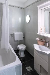a white bathroom with a toilet and a sink at Apartman Nico, Volosko, PET FRIENDLY in Opatija