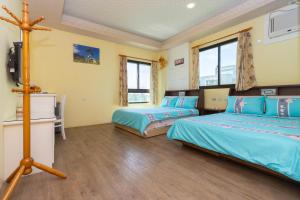 a bedroom with two beds and a tv in it at 曉翠軒親子民宿 in Wujie