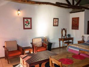 a room with a bed and chairs and a table at Thaba Manzi Ranch in Magaliesburg