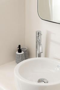 a white sink in a bathroom with a mirror at Archon Seaside Retreat in Plaka