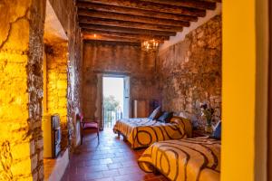 a bedroom with two beds in a stone wall at Villas de Santa Ana in Manuel F. Martínez