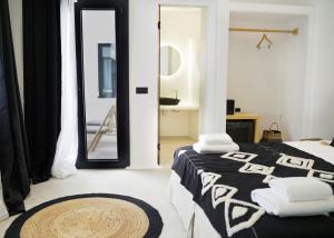 Un dormitorio con una cama en blanco y negro y un espejo en King's Suites, en Kamari