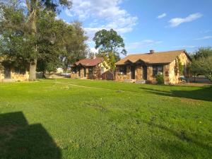 a house in a yard with a grass field at Grand Canyon Cabins in Fredonia