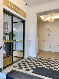 a lobby with a checkered floor and a glass door at Hotel Bee Fang in Hamburg