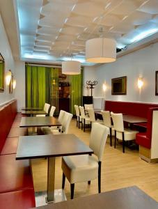 une salle à manger avec des tables et des chaises blanches dans l'établissement Hotel Bee Fang, à Hambourg