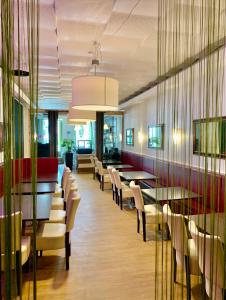 ein Restaurant mit Tischen und Stühlen in einem Zimmer in der Unterkunft Hotel Bee Fang in Hamburg
