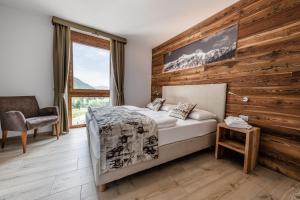 ein Schlafzimmer mit einem Bett und einer Holzwand in der Unterkunft Villetta Val Di Sole in Commezzadura