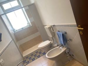 a small bathroom with a toilet and a window at Le Maioliche BLU Sferracavallo in Sferracavallo
