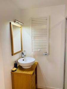 La salle de bains est pourvue d'un lavabo blanc et d'un miroir. dans l'établissement Chaumière des Dunes à 350m de la plage de Kerhillio, à Erdeven