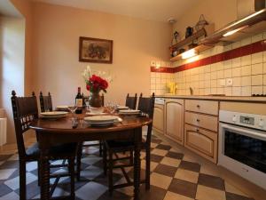 eine Küche mit einem Tisch und Stühlen in der Unterkunft Gîte Bournoncle-Saint-Pierre, 4 pièces, 6 personnes - FR-1-582-278 