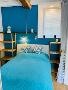 Dormitorio azul con cama y pared azul en Chaumière des Dunes à 350m de la plage de Kerhillio, en Erdeven