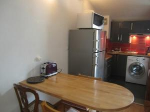 eine Küche mit einem Holztisch und einem Kühlschrank in der Unterkunft Studio Brides-les-Bains, 1 pièce, 4 personnes - FR-1-512-242 in Brides-les-Bains