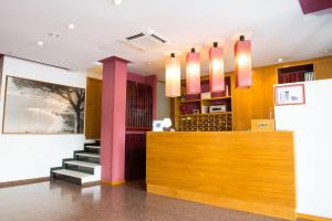 a lobby with a bar with pink columns and a staircase at Hotel Celymar in Benidorm