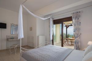a bedroom with a canopy bed and a balcony at Family Villa Rousa in Rethymno with Pool, BBQ and Kids Area in Loutra