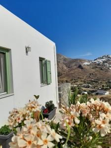 a white building with flowers on the side of it at Magda house in Livadi