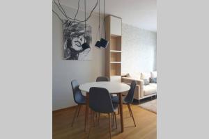 a living room with a table and chairs and a couch at Diagonala 2 in Novi Sad