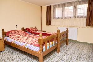 a bedroom with a wooden bed and a window at Apartmani Malica in Soko Banja