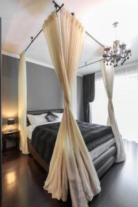 a bedroom with a bed with a mosquito net at Tampa Gardens Apartments - Adults Only in Braşov