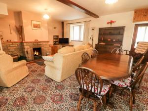 a living room with a table and a fireplace at Poppy Cottage in Settle